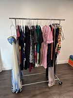 Assorted ladies dresses on a metal clothing rack showcasing various colors, styles and prints predominantly in medium size