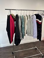 Photo showing assorted ladies sweaters hanging on a rack from left to right in various colors and styles