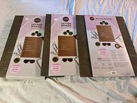 Three Core letter boards in original packaging, brown felt with wooden frame showing front and back packaging with product details.