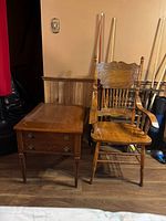 Photo of vintage wooden chair next to rectangular wooden side table with drawer