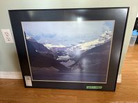 Framed Leyda Campbell artwork showing mountain landscape with snow caps and a lake.