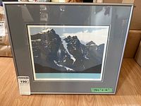 Framed limited edition print showing snow-capped mountain peaks with gray mat and silver frame, marked 18.5 x 16 inches.