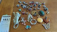 Full lot overview on wood surface showing rings, brooches, pendants and earrings