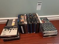 Photo showing the full set of DVDs and CDs arranged on the floor, including movie titles and music albums.