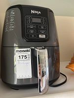 Front view of the black Ninja Air Fryer showing the handle and MaxSold label with lot number.
