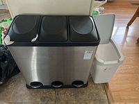 Full front view of the triple recycling sorting bin unit and the white plastic garbage can beside it.