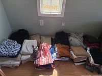 Photo of entire clothing pile including jackets, pants, shorts, tops, sweaters and more in neutral and colorful patterns.