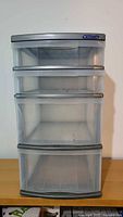 Front view of gray plastic storage unit showing four semi-transparent drawers and Sterilite label on top drawer.