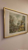 Framed print hanging on wall showing overall artwork and gold metal frame