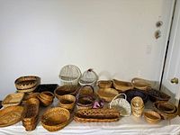 Wide view of over 20 varied wicker baskets including round, oval, rectangular shapes with different colors and handles