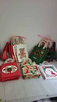 Gift bags organized in stacks with holiday themed prints including snowmen, teddy bears, and festive patterns.