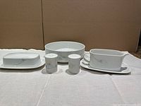 Full view of all seven pieces: butter dish with base, serving bowl, salt and pepper shakers, gravy boat with underplate.