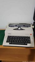 Front view of Olympia Report Electric typewriter with visible keyboard and platen.