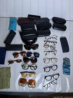 Overall view of assorted eyeglass frames, sunglasses, and cases