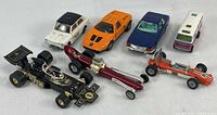 Seven Corgi branded die cast cars including three racers, seen from front and top angles.