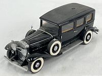 Front-side view of black 1930 Cadillac Imperial Sedan diecast model, showing overall condition, design, and whitewall tires.