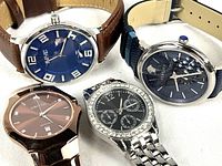 Four wristwatches shown together, different brands and styles, showcasing dials and bands