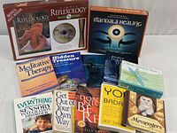 Photo showing the entire collection of books and kits, including 'Simply Reflexology' boxed set, 'Mandala Healing Kit', and various self-help and therapy books.
