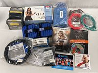 Top down photo showing boxed ankle weights, resistance stretching bands, multiple fitness DVDs including Chalean Extreme and The Challenge, and pump in the rubber bands.
