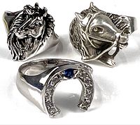 Photo of three sterling silver rings including two horse head rings and one horseshoe ring with stones.
