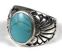 Front angled view of sterling silver ring with oval turquoise stone and embossed designs on the sides.