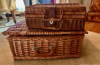two stacked wicker baskets, showing size difference and leather latches