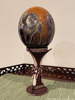 Full view of ostrich egg on carved elephant stand