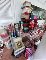Overall lot showing storage totes, wrapping paper, tins and baskets