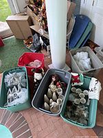 Multiple bins holding assorted Christmas decorations such as glitter stars, white houses, cotton snow and mugs