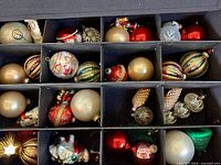 Open storage box showing compartments filled with assorted ornaments