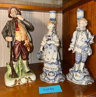 All three porcelain figures on shelf: Dresden candlestick pair and Capodimonte hunter