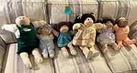 Group shot of six vintage Cabbage Patch Kids dolls on couch