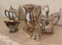 All six silver-plate serving pieces displayed together