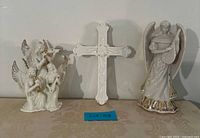 Group shot of both angel statues and cross