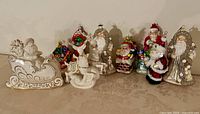 All nine items lined up: Lenox sleigh, reindeer, seven glass Santa ornaments