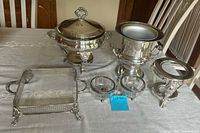 Group shot of all silver-plate serving pieces and glass bowls