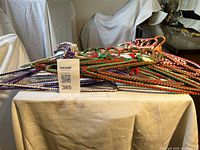 Stack of multicolour braided nylon fabric metal hangers on table