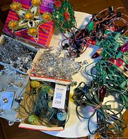 Overview of lot with tree toppers, light strings, tinsel, garlands