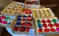 Overview of six boxes of assorted vintage ornaments on table