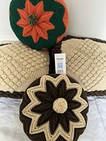 Front view showing two square pillows, brown-beige round pillow, green-orange round pillow