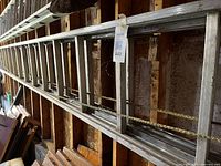 Full view of aluminum extension ladder mounted on wall studs