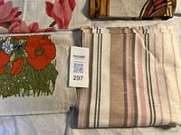 Assorted folded tea towels and striped fabric visible with lot tag