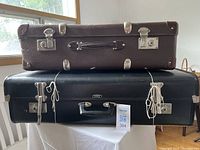 Stacked view of both suitcases showing colors, size difference, hardware