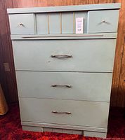 Front view of blue dresser showing four drawers and hardware