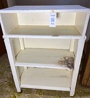 front view showing three shelves, stain on bottom shelf