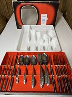 Full set in red presentation box alongside white cutlery tray and original outer box