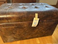 Closed ottoman showing exterior texture, tufting, and embossed design