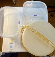 Top view showing cake carrier base and dome with handle alongside two clear containers