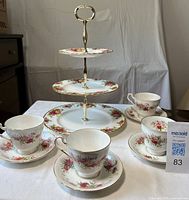 Front view of cake stand with four teacup sets displayed