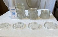 Stacks of clear glass mason jar lids displayed upright and flat